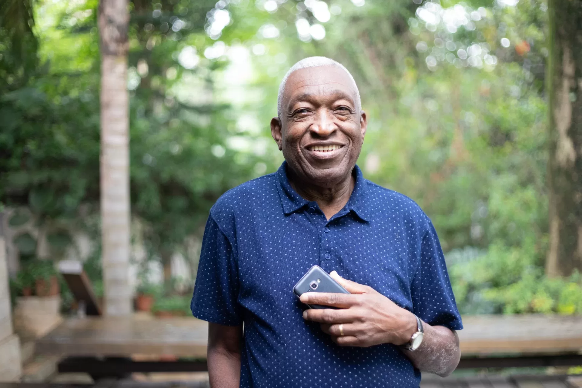 Smiling Elderly Man Holding A Mobile Phone