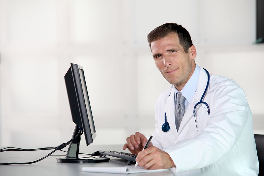 Closeup of doctor at his desk in front of computer