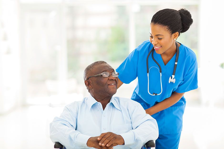 A Nurse Assisting Patient In Wheelchair